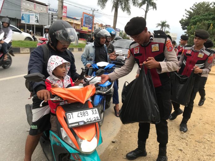 Personel Ditsamapta Polda Sultra membagikan tagi takjil kepada masyarakat di Jalan Martandu dan Jalan Malaka, Kecamatan Poasia, Kota Kendari, Jumat 29 Maret.