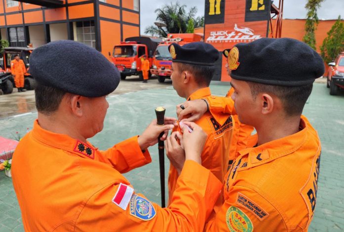 Kepala KPP Kendari Muhammad Arafah saat menyematkan pin kepada perwakilan personel siaga SAR khusus mudik lebaran 2024.